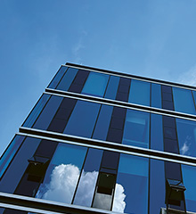 Hochhaus mit Glasfassade und blauem Himmel