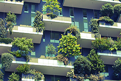Hausfront mit bepflanzten Balkonen – Umwelt schonen mit Elektrofahrzeugen und Wallboxen von ABL